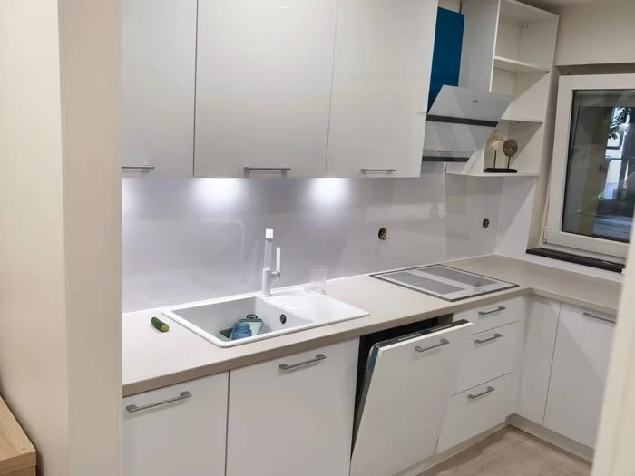Açık renk tezgahlı, beyaz evyeli ve dolap aydınlatmalı beyaz mutfak